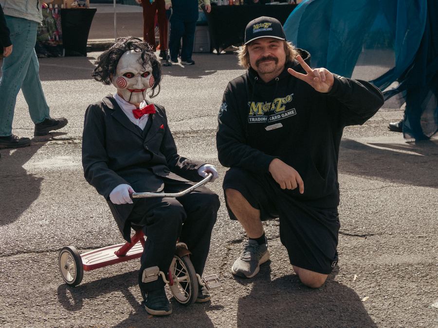 A Jigsaw puppet on a tricycle with a smiling fan