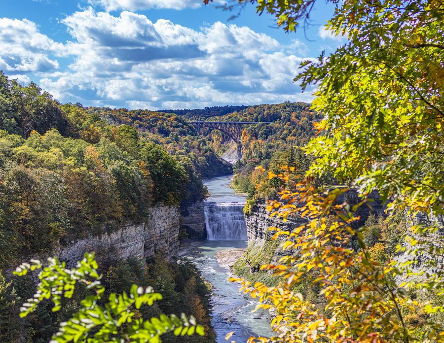 The gorge and a distant waterfall framed by autumn leaves