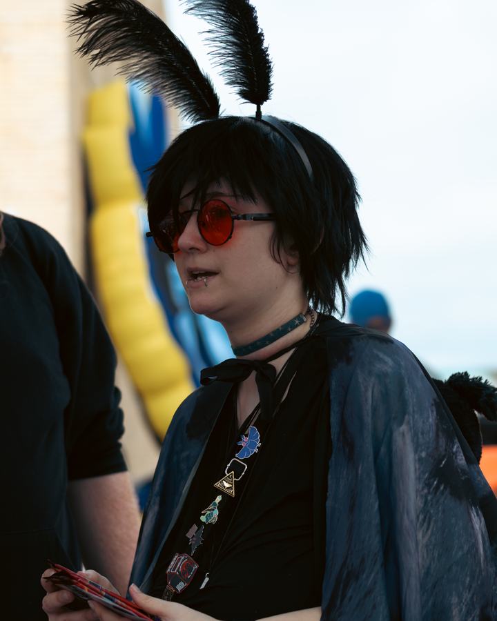 A festival-goer in red glasses and feathered ears