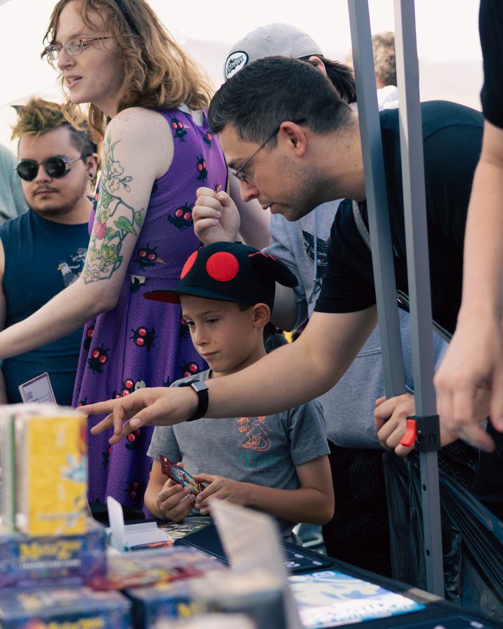 A young fan pointing out cards at the booth