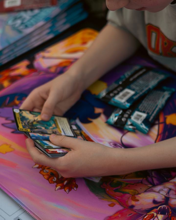 Hands sorting cards over a playmat