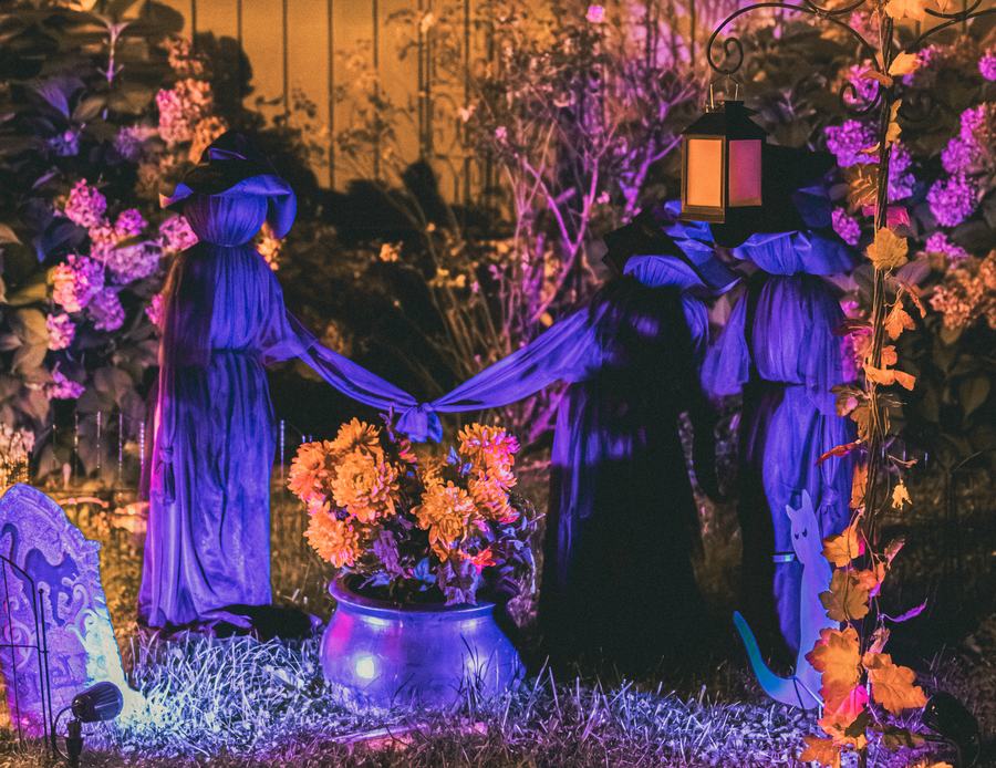 Witch figures around a cauldron in violet light